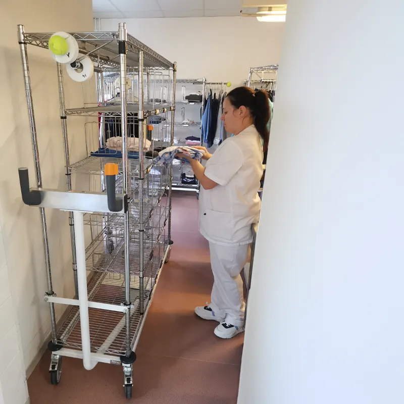Un agent des services hospitaliers avec chariot pour le linge